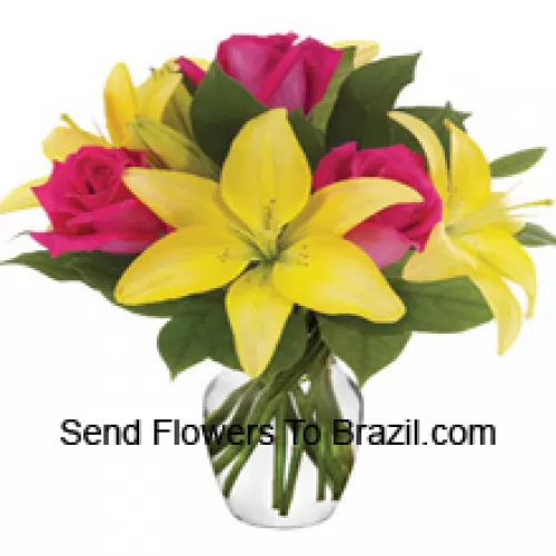 Rosa Rosen und gelbe Lilien mit saisonalen Füllern, wunderschön in einer Glasvase arrangiert