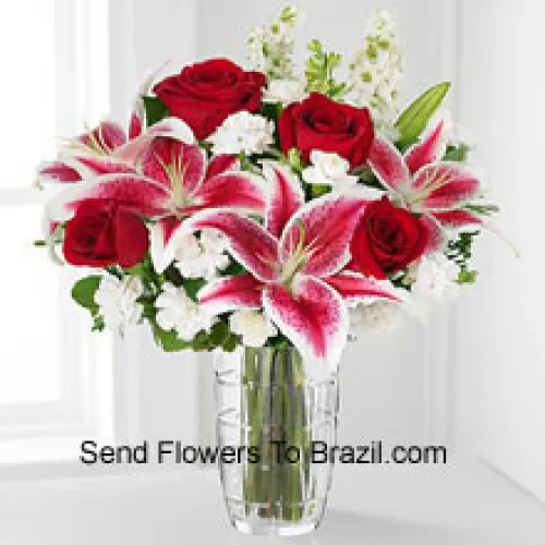 ورود حمراء، زنابق وردية مع أزهار بيضاء متنوعة في فازة زجاجية